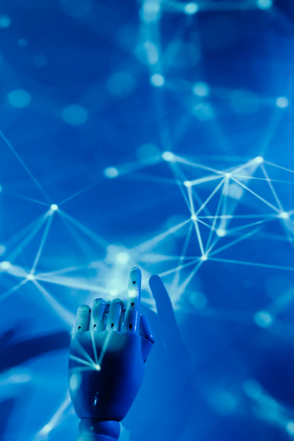 Robotic hand reaching toward a glowing network of connected nodes