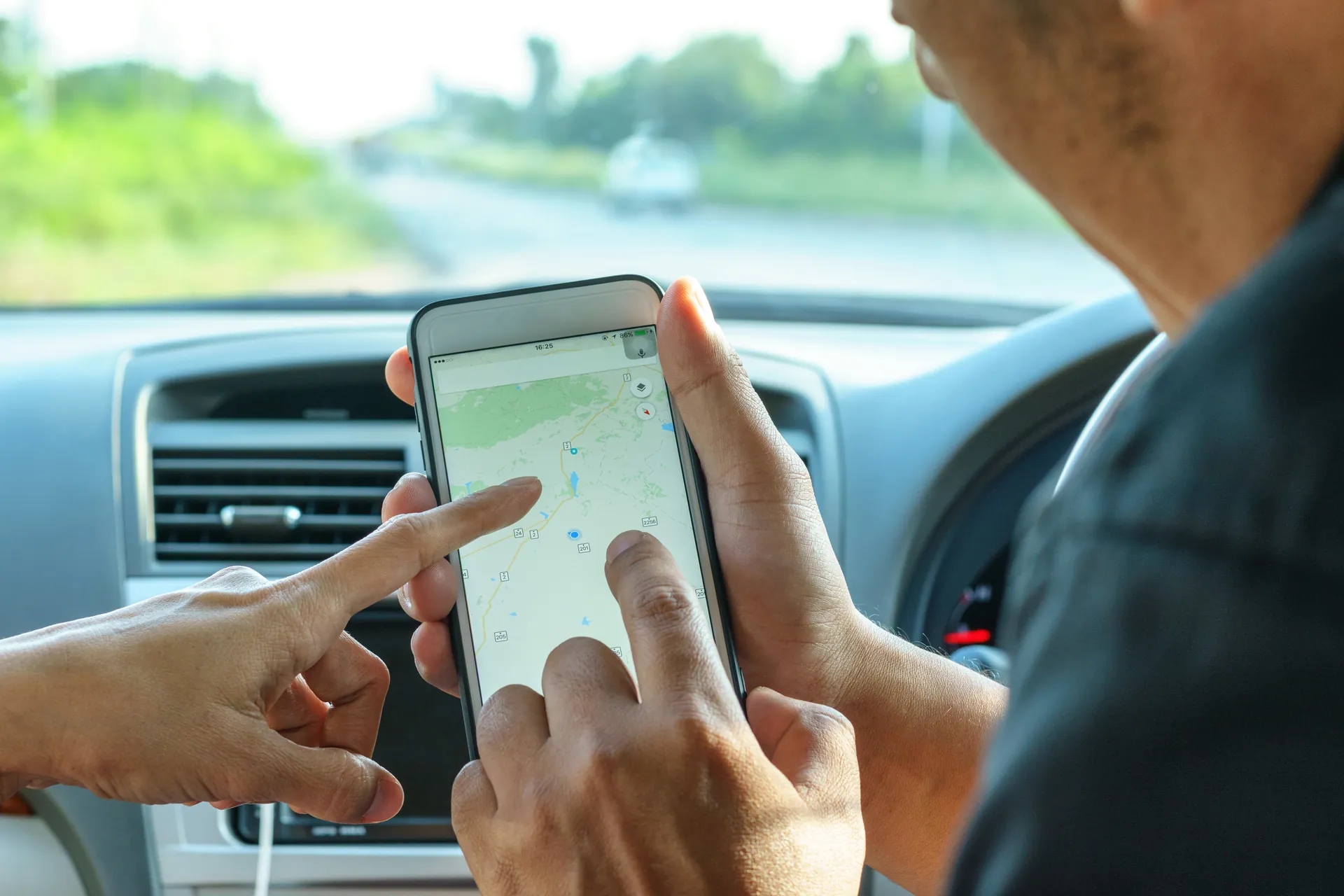 A person in a car using Google Maps on a phone to navigate to a local business — intent that happens entirely inside Search and Maps, off your website